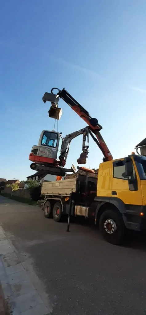 Bagger wird mit Kran angehoben