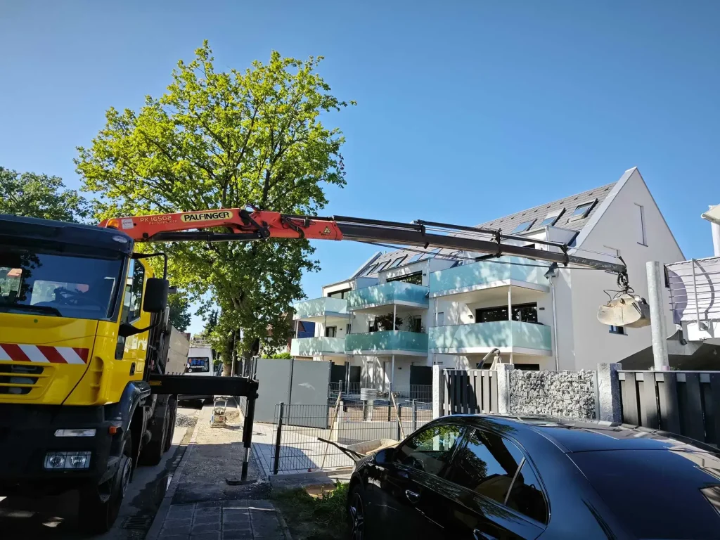 Kran hebt Last an Gebäude